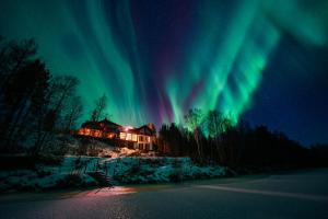 a house with the aurora in the sky at Reisa Lodge in Storslett