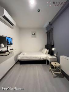 a small room with a bed and a tv at Havona Hotel - Kulai in Kulai