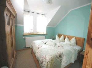- une chambre dotée d'un lit avec un mur bleu dans l'établissement Hotel/Pension Bradhering, à Ahrenshoop