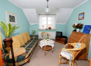 a living room with a couch and a table at Hotel/Pension Bradhering in Ahrenshoop