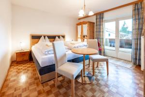a hotel room with a bed and a table at Villa Frieda in Zell am See