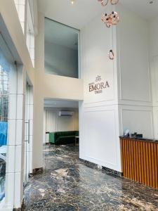 a lobby of a building with a sign on the wall at Hotel Emora Tree in Mysore