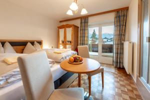 una habitación de hotel con 2 camas y una mesa con un bol de fruta. en Villa Frieda, en Zell am See