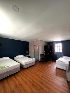 three beds in a room with wooden floors and blue walls at Phi Phi Inn in Phi Phi Islands