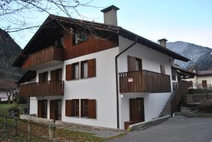 Casa blanca con balcones de madera y valla en La Pineta - Appartamenti In Villetta, en Pinzolo