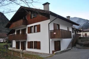 a white house with wooden balconies and a fence at La Pineta - Appartamenti In Villetta in Pinzolo