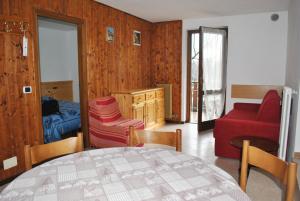sala de estar con mesa y sofá rojo en La Pineta - Appartamenti In Villetta, en Pinzolo