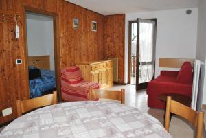 a living room with a table and a red couch at La Pineta - Appartamenti In Villetta in Pinzolo