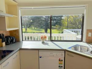 cocina con fregadero y ventana grande en Scherff Road Holiday Home en Auckland