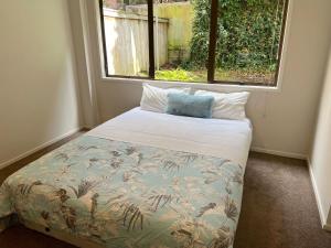 Cama en habitación con ventana en Scherff Road Holiday Home en Auckland