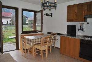 uma cozinha com uma mesa e cadeiras e uma cozinha com uma janela em La Pineta - Appartamenti In Villetta em Pinzolo