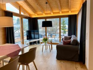 a living room with a couch and a table with a television at Alpenchalet Iseler in Oberjoch