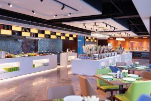 a restaurant with tables and chairs and a buffet at Hampton by Hilton Chengdu Xibo City in Chengdu
