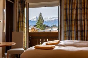 a bedroom with a bed and a large window at Chalet Frieda by Via Montes in Zell am See