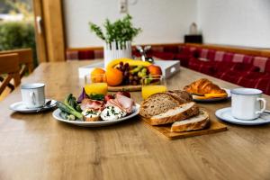 una mesa de madera cubierta con platos de comida y tostadas en Villa Frieda en Zell am See