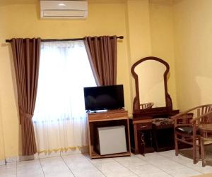 a living room with a television and a mirror at Hotel My Lovina in Lovina