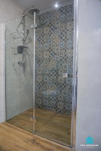 a shower with a glass door in a bathroom at Pod Brzozami Apartamenty Villa Solny in Ustronie Morskie