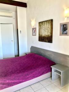 a bedroom with a purple bed with a purple rug at Le Maset in Saintes-Maries-de-la-Mer