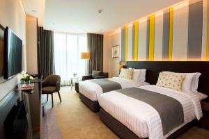 um quarto de hotel com duas camas e uma secretária em Lancaster Bangkok em Bangkok