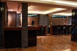 a bar in a hotel lobby with black stools at Hotel California Urubamba in Urubamba