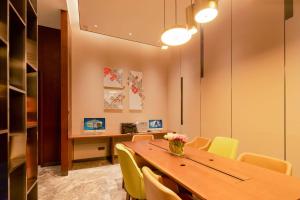 Hampton by Hilton Chengdu Xibo City في تشنغدو: غرفة طعام مع طاولة وكراسي صفراء