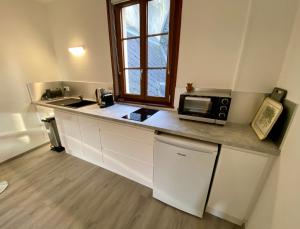 a kitchen with a counter with a microwave and a window at Le Nid Dieppois - Sur les Quais de Dieppe, Entre Port & Plage in Dieppe