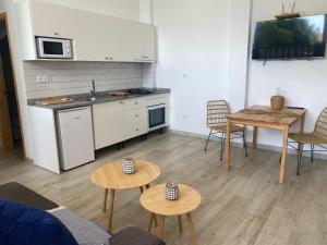a living room with a kitchen and a table and chairs at SUNNY DAY DELUXE 1 B in Arguineguín