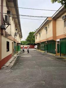 OYO 1026 Evita Hotel Bacoor في Cavite: اثنين من الرجال يسيرون في زقاق بين مبنيين