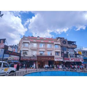 a busy city street with a building in the middle at Hotel Krishna in Katra