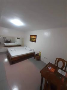 ein Schlafzimmer mit einem Bett und einem Tisch in einem Zimmer in der Unterkunft OYO 1026 Evita Hotel Bacoor in Cavite