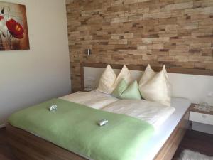 a bedroom with a bed with green sheets and pillows at Appartement Mühlbacher in Wagrain