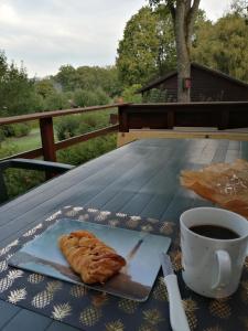 a table with a cup of coffee and a croissant at Chalet 94 la boverie in Rendeux