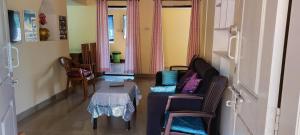 uma sala de estar com uma mesa e um sofá em Chesna Cottage em Madikeri