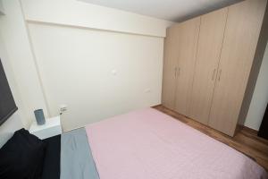 - une chambre avec un grand lit et une armoire dans l'établissement Seacoast Apartments 1 !, à Kamena Vourla