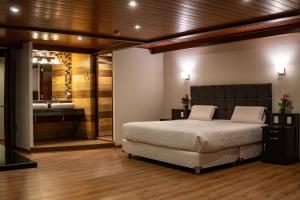 Hotel California Urubamba في أوروبامبا: غرفة نوم بسرير وحمام مع حوض