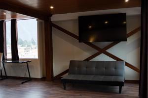 a living room with a couch and a flat screen tv at Hotel California Urubamba in Urubamba