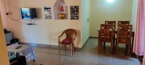 Habitación con 2 sillas, mesa y TV. en Chesna Cottage, en Madikeri