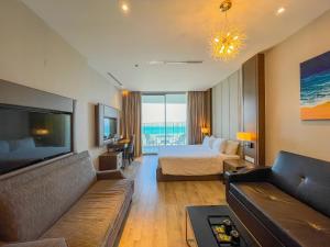 a hotel room with a bed and a couch at Luxury Seaview Panorama Nha Trang by Luna in Nha Trang +65 photos