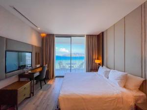 a hotel room with a bed and a desk and a television at Luxury Seaview Panorama Nha Trang by Luna in Nha Trang