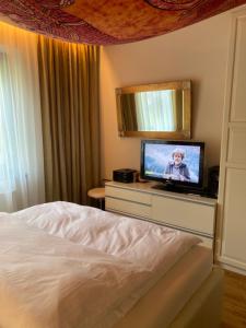 a bedroom with a bed and a television on a dresser at Golden Rooms in Völkermarkt