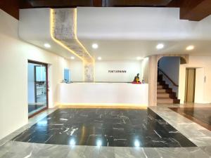 a lobby with a black tile floor and a staircase at Rimtarn Hotel Pakchong in Pak Chong