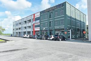 een groot gebouw met auto's geparkeerd op een parkeerplaats bij Capital O 90882 Padi Hotel in Alor Setar