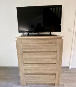 a tv on a wooden dresser with a tv on it at Le Nid Dieppois - Sur les Quais de Dieppe, Entre Port & Plage in Dieppe