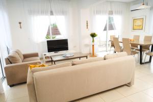 Sala de estar con 2 sofás y TV en Narcissos Villa 2, en Protaras