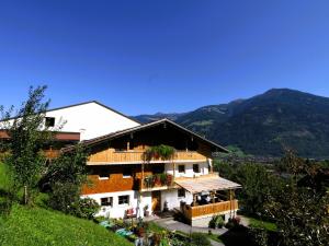 a building on a hill with mountains in the background at Apartment in Fügen near Spieljochbahn in Fügen