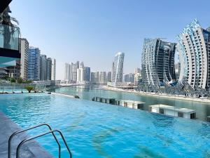 a large swimming pool in a city with tall buildings at Binghatti canal suite , smart home new brand,KINGS in Dubai