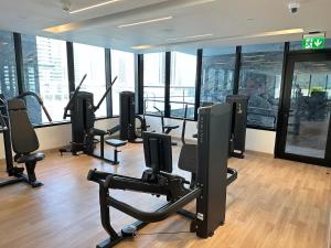 a gym with cardio equipment in a building with windows at Binghatti canal suite , smart home new brand,KINGS in Dubai