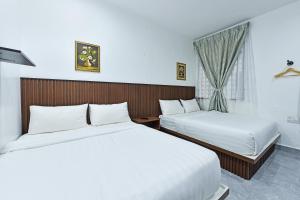 um quarto de hotel com duas camas e uma janela em Capital O 90882 Padi Hotel em Alor Setar