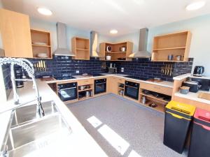 a large kitchen with a sink and a stove at Adventure Wanaka Hostel in Wanaka