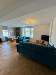 巴斯的住宿－Haus of Sulis, City Centre Apartment with Lift Access，客厅配有蓝色的沙发和电视